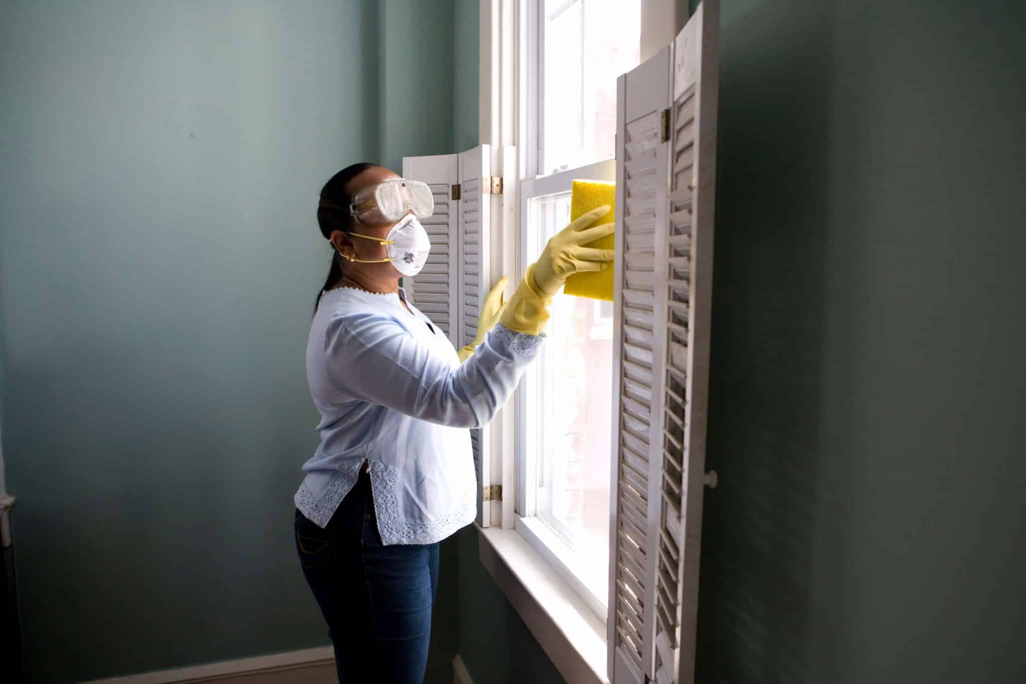 una donna pulisce una finestra